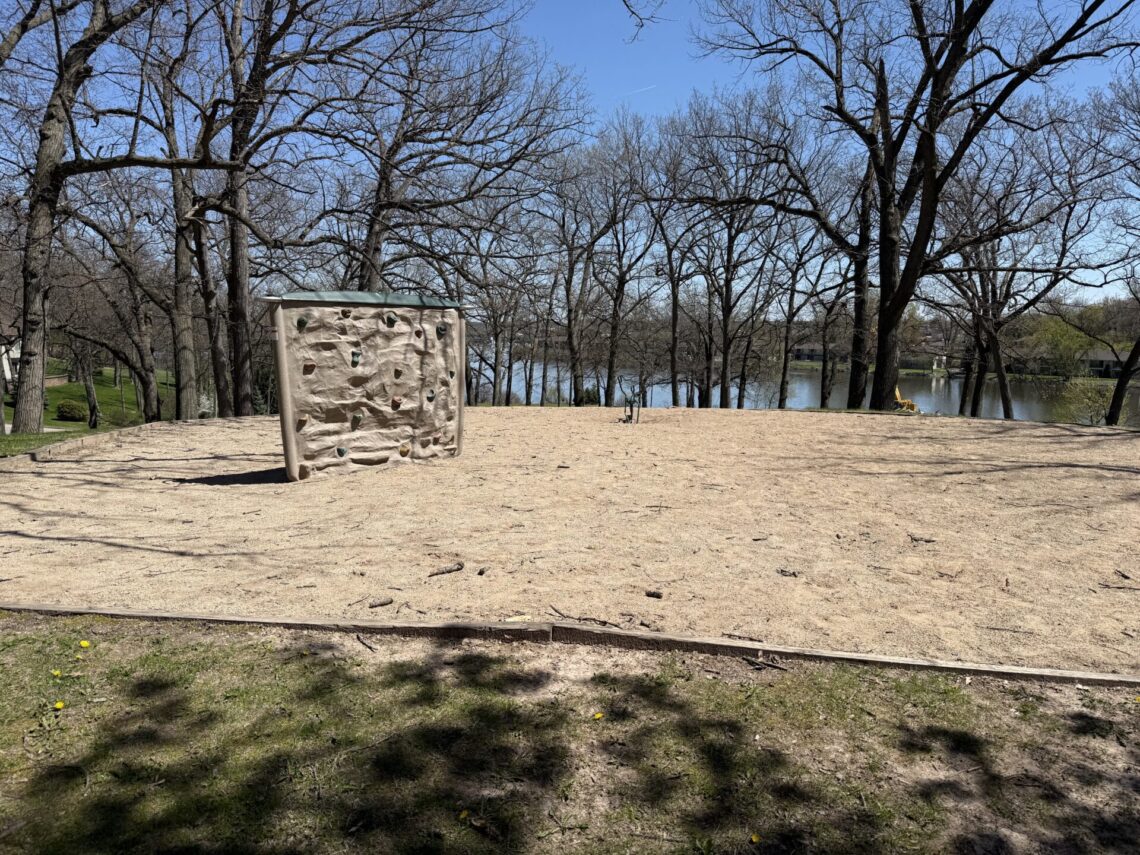 Picture of short, tan rock-climbing walls in a sand pit